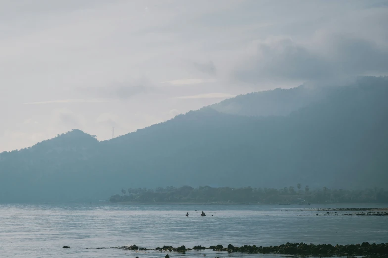 a lake that has people on it and a few mountains