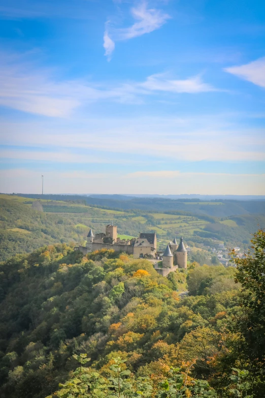 a castle sits on top of a small hill overlooking a valley