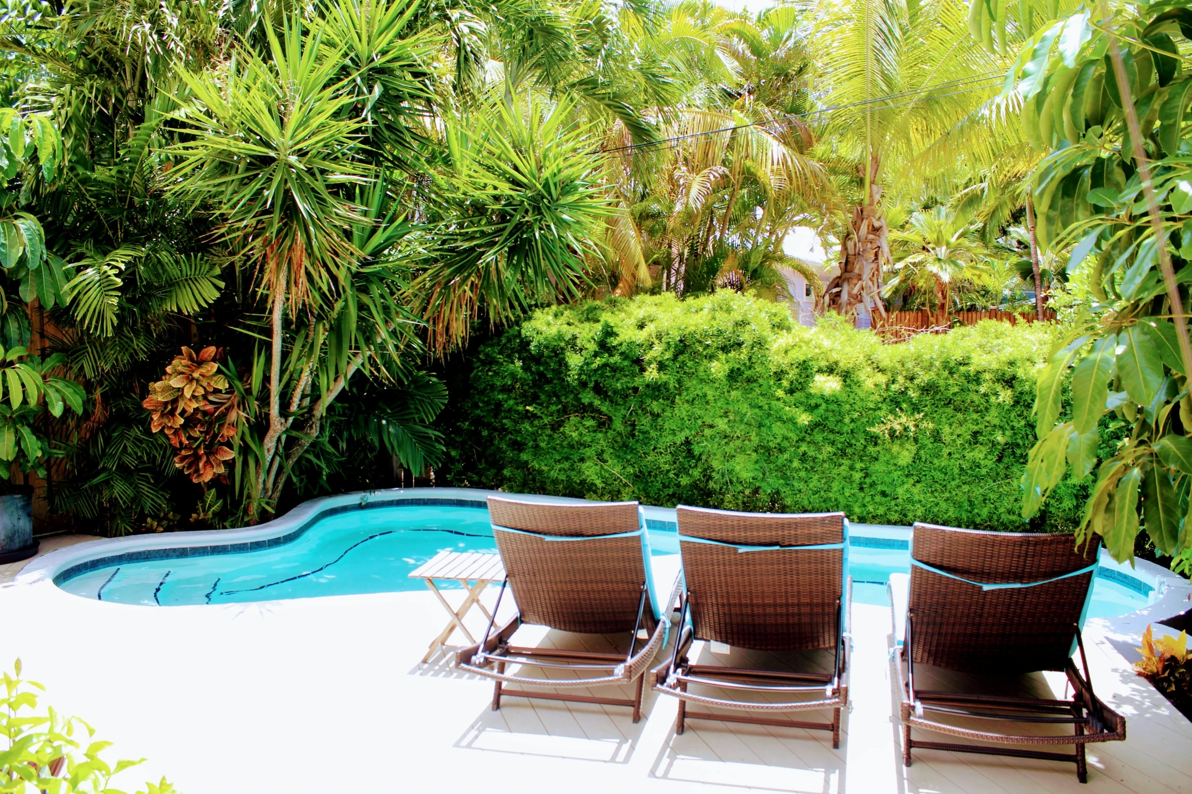 four chairs that are sitting near a pool