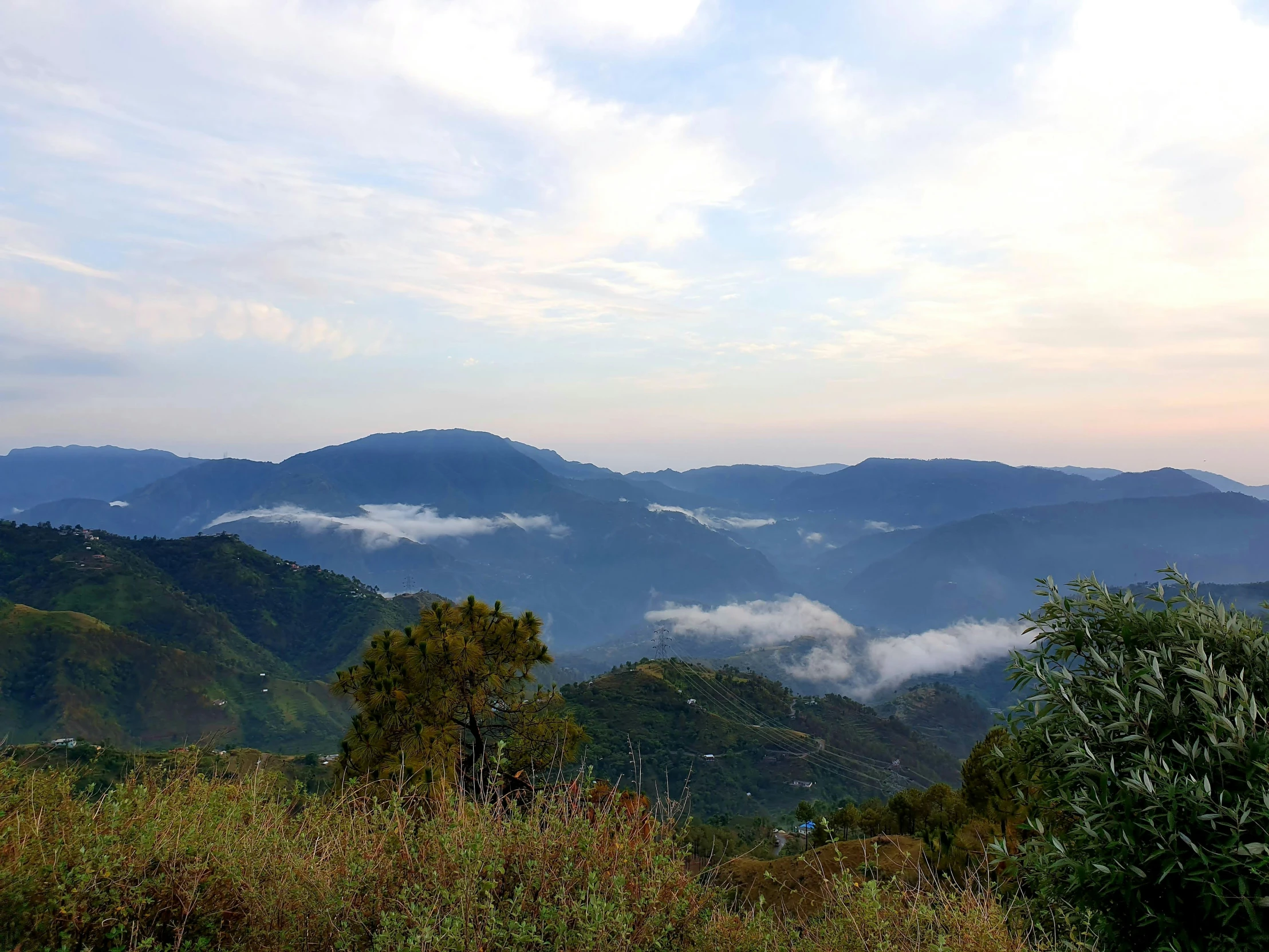 a hazy mountain landscape with clouds in the sky