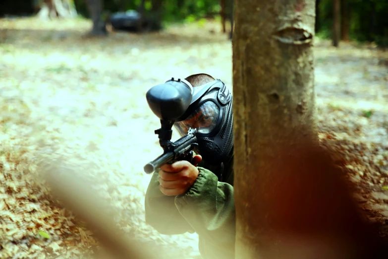 a paintball player playing in the woods