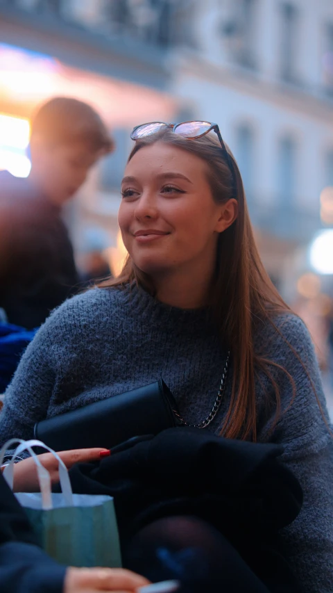 a woman is sitting on the curb, smiling