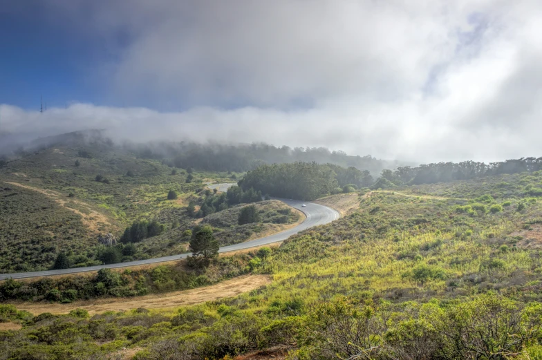 a long winding road winds through an open valley