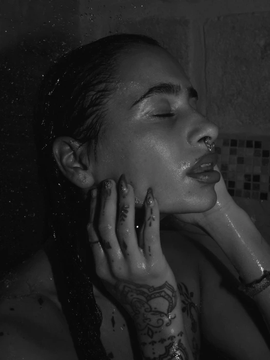 woman with large black tattooed arm taking a shower
