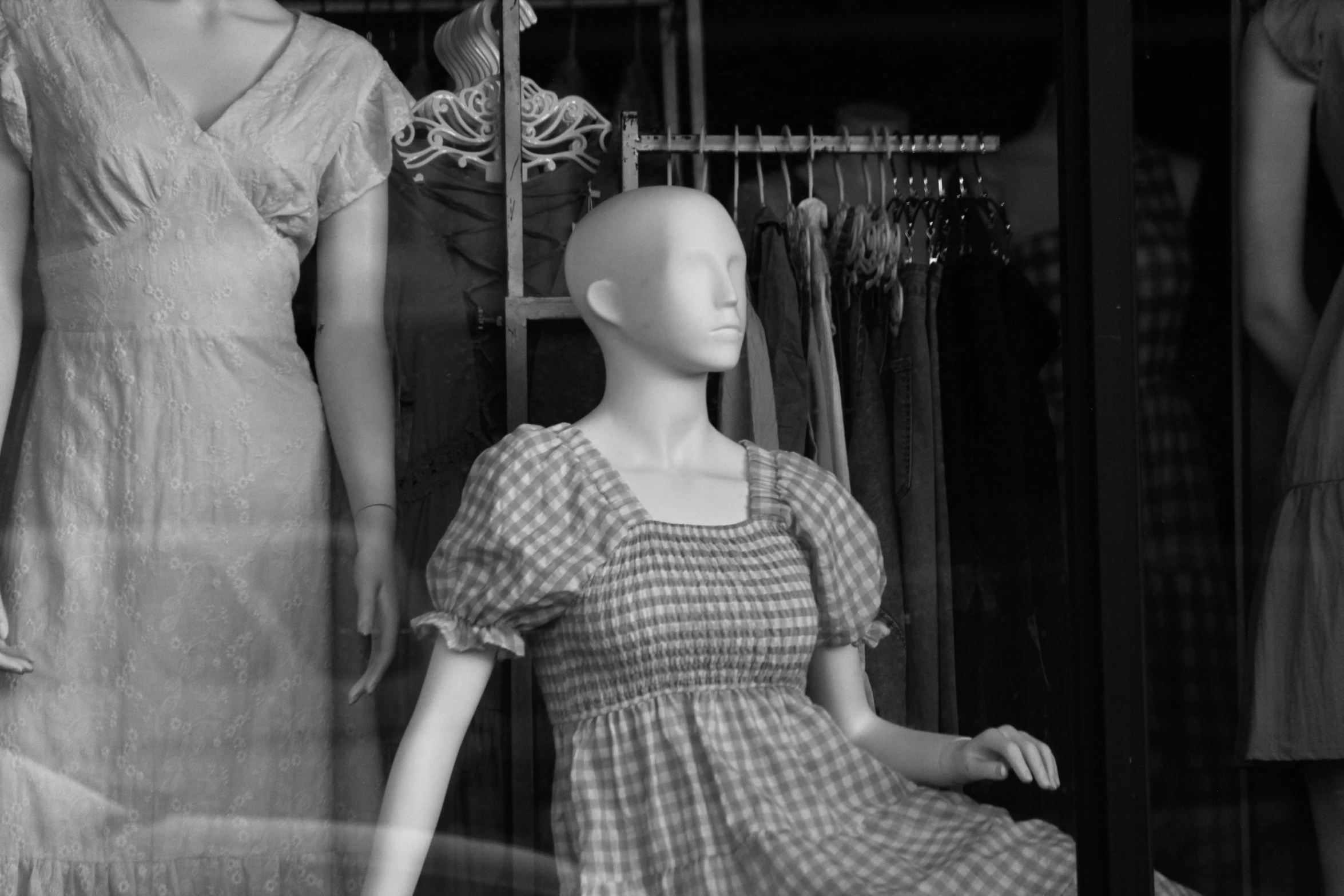 a dummy and a mannequin are placed beside each other in front of a store window