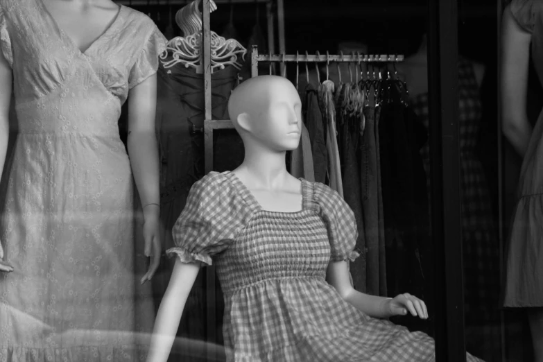 a dummy and a mannequin are placed beside each other in front of a store window