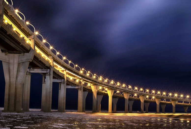 the view of the long and wide span of a bridge at night