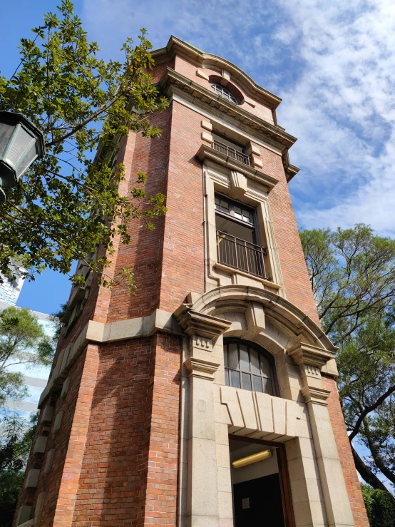 there is a tall clock tower that has a balcony and a second story with windows above it