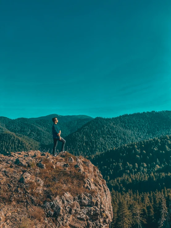 a man standing on top of a rocky cliff