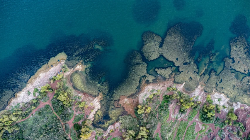 the ocean water has different colored rocks on it