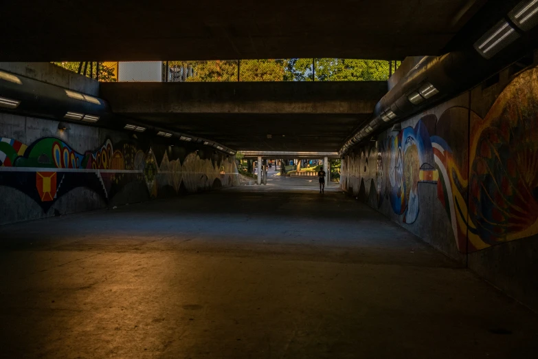 an outdoor covered walkway with graffiti and light