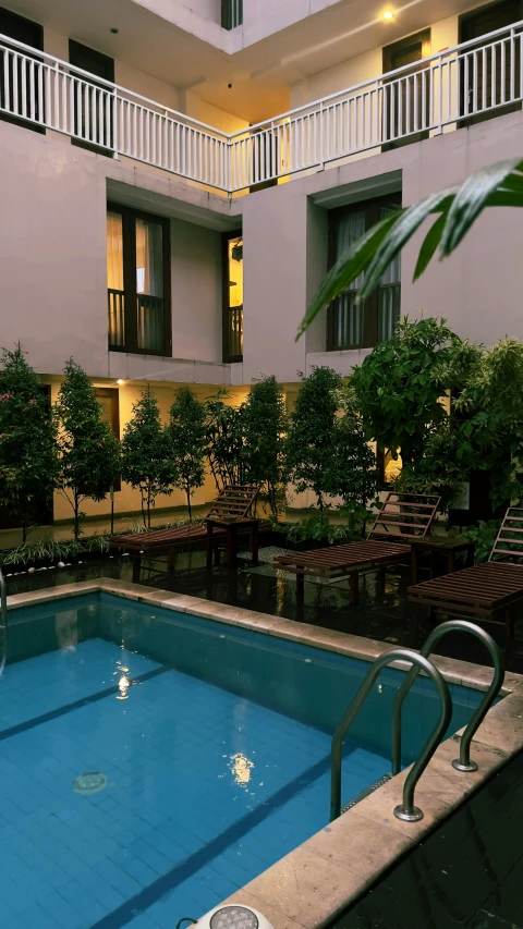 a pool surrounded by plants in an apartment building