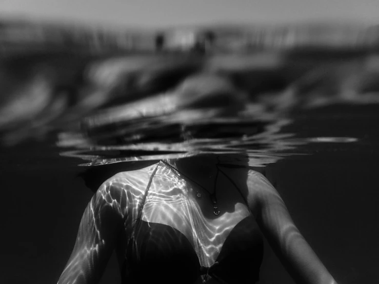 a woman swimming under water with two people behind her