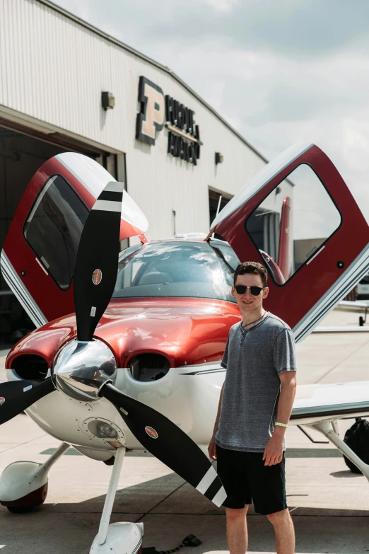 a man standing by a plane in front of a building