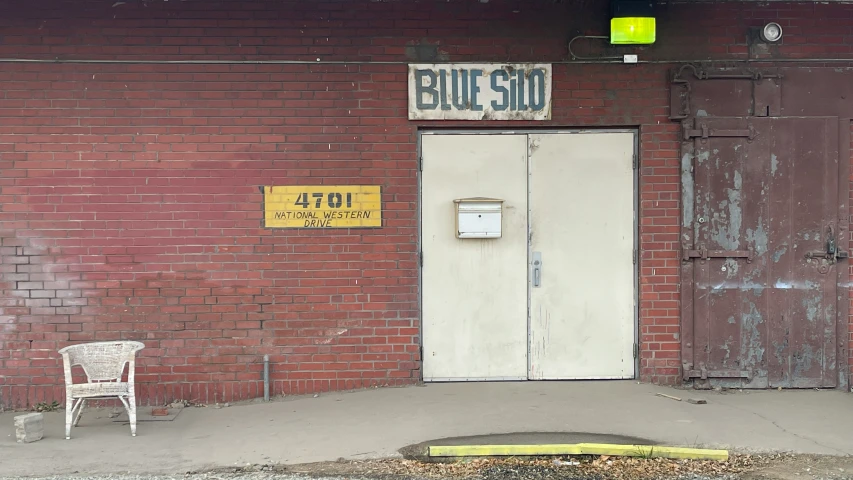 a couple of white chairs sitting outside of a building