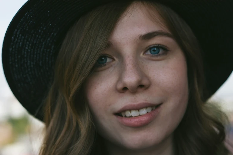 close up of a woman with blue eyes and hat