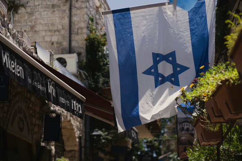 an israeli flag flies outside a shop in old city