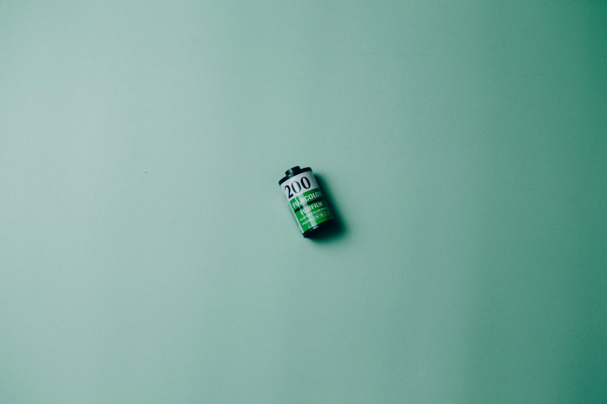 a green bottle sitting on a green background