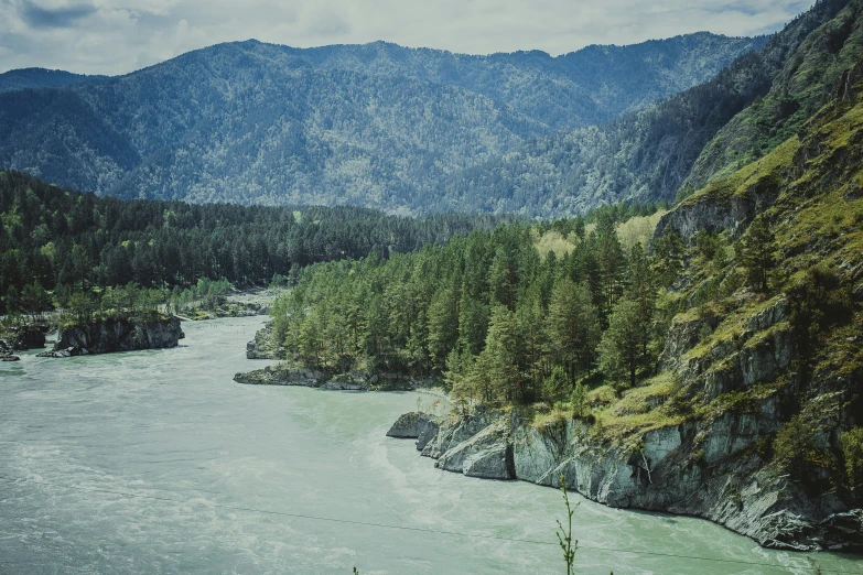 a river surrounded by mountains in the distance