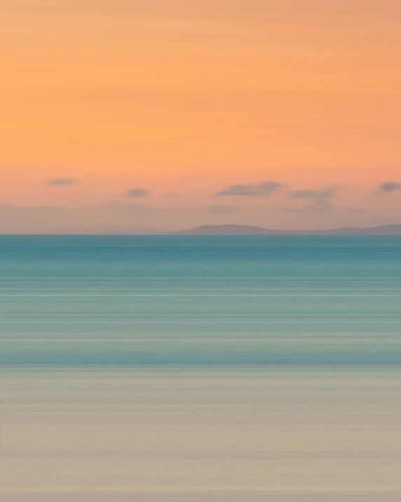 a surfer walking on the beach during sunset