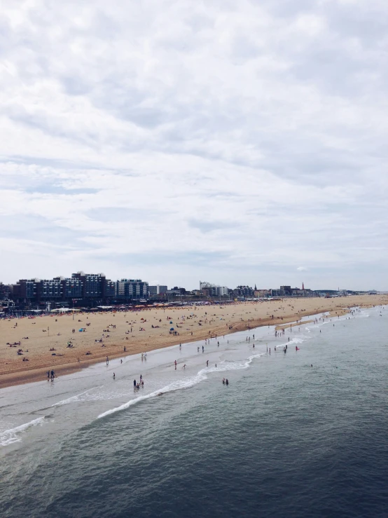 people on the beach and in the ocean and a beach near an airport