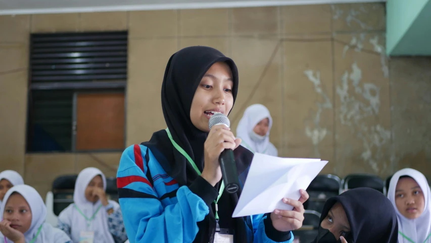 a woman singing in front of her students