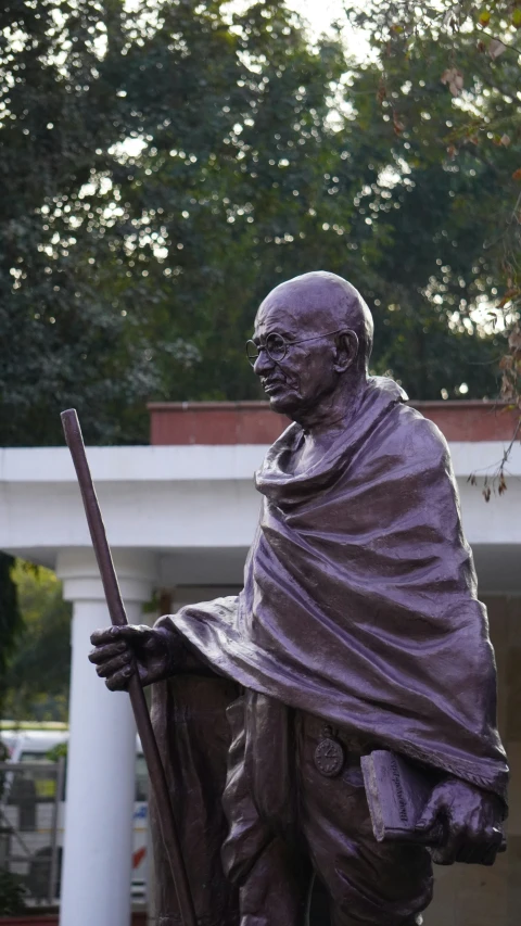 statue of a man with a cane on the ground