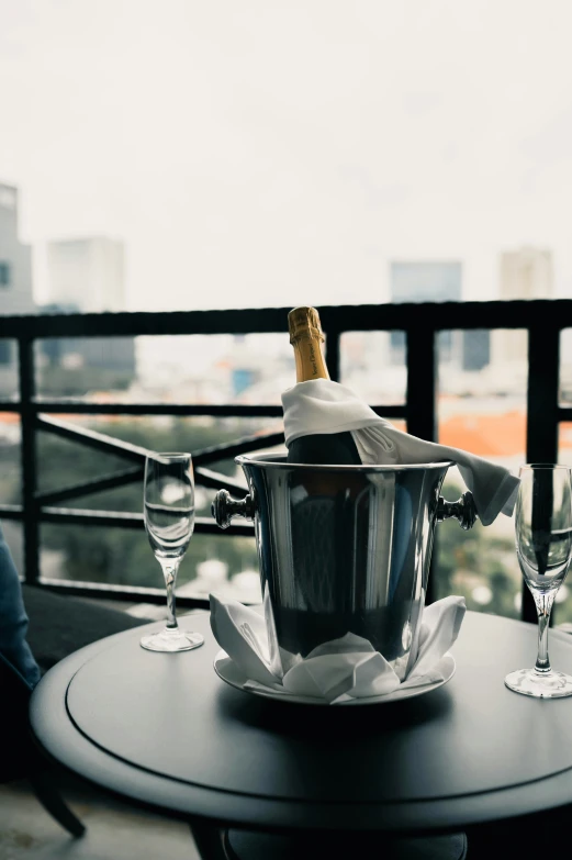 a wine bucket filled with champagne and glasses on a table