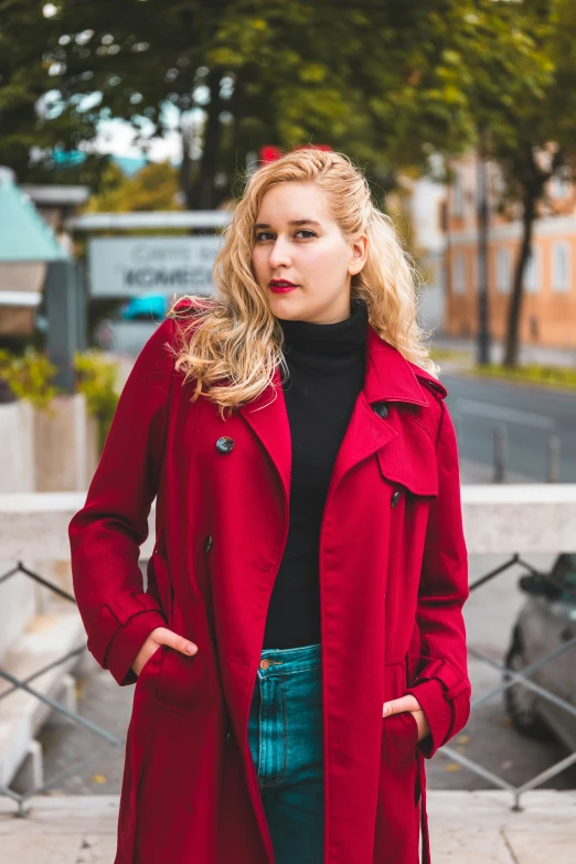 a woman is standing on a sidewalk with her hands in her pockets