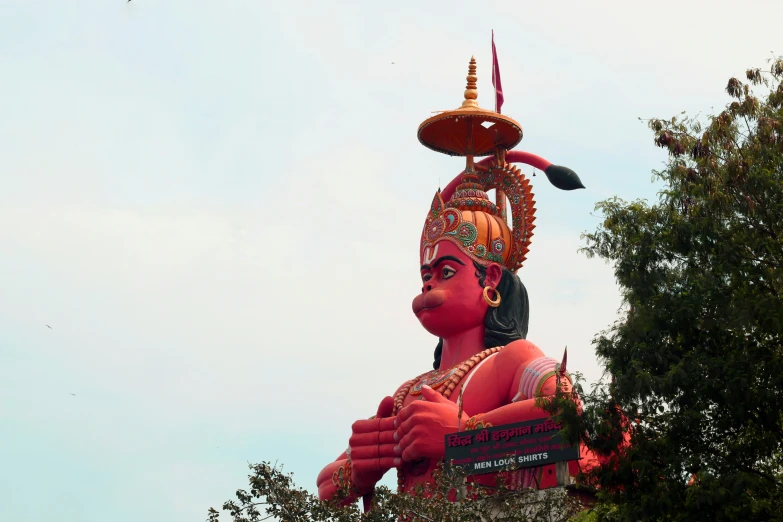 the large statue is standing next to a tree