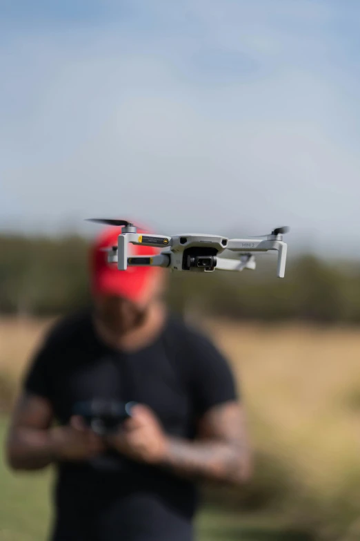 a man holding a camera and small flying vehicle