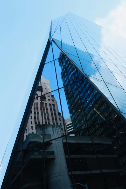 the building with its very high rise is reflected in its glass facade