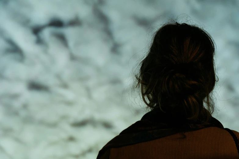 a woman looks up at an overcast sky