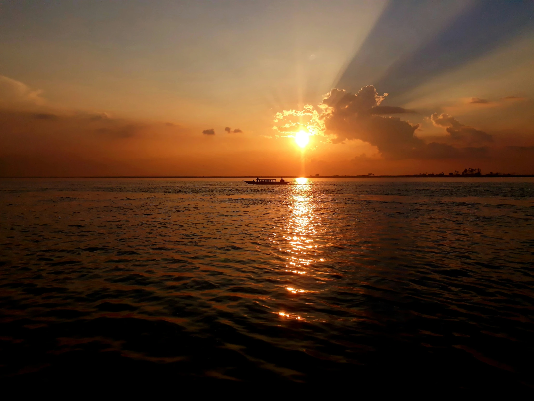 a boat on the water at sunset