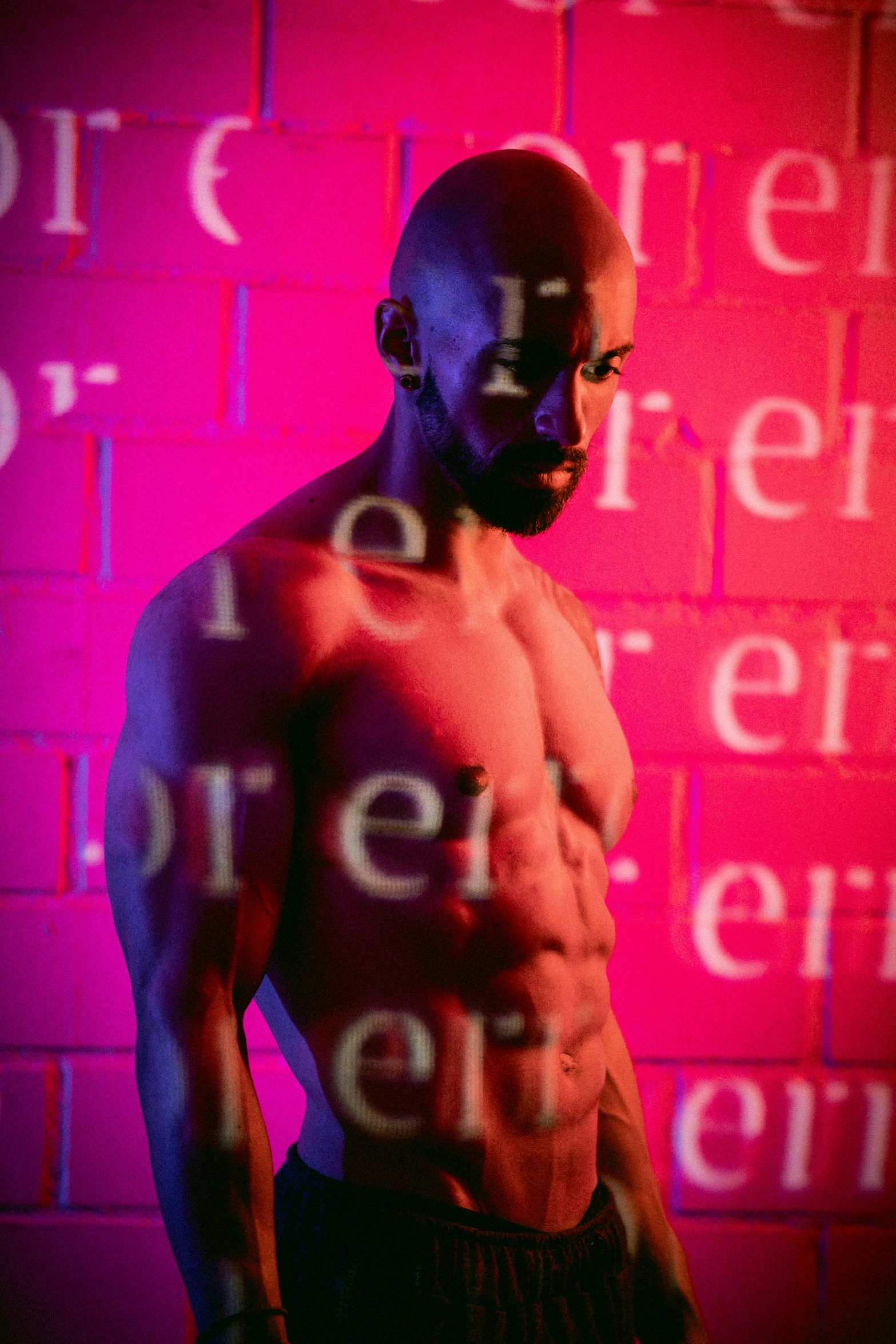 the man is standing in front of a wall that has different words