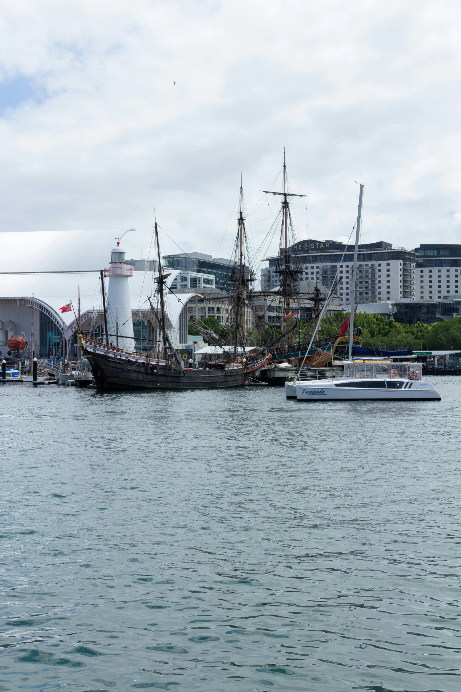 three old style sailboats are tied to the docks