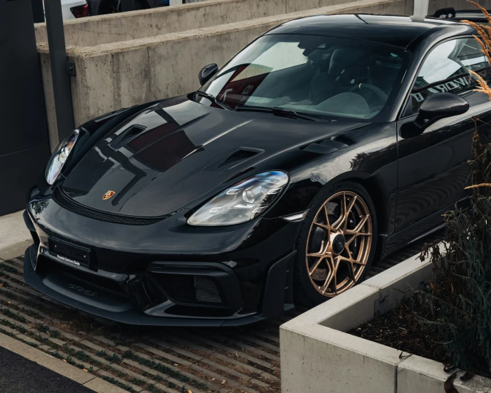 a porsche car with gold accents sitting in front of a building