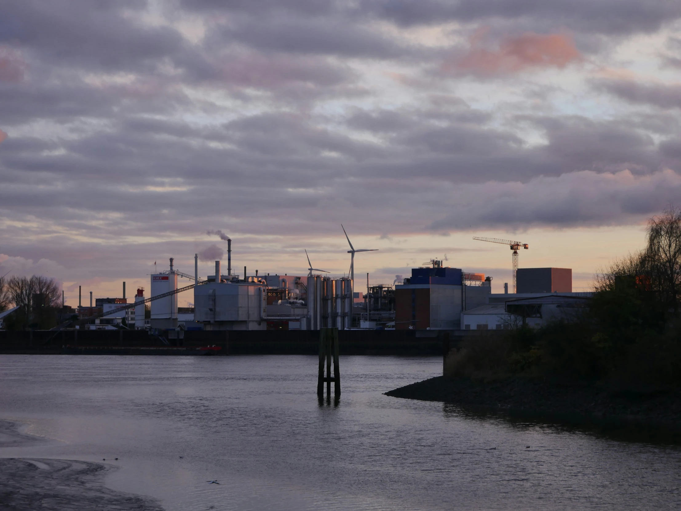 a body of water with power plant in the distance