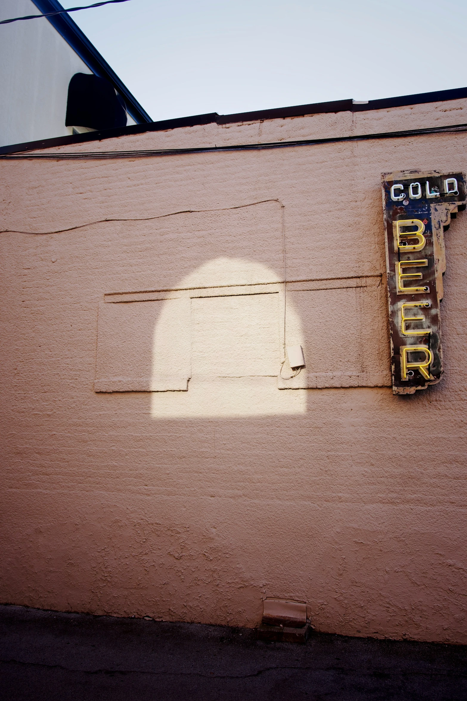 a faded coke sign on a building wall