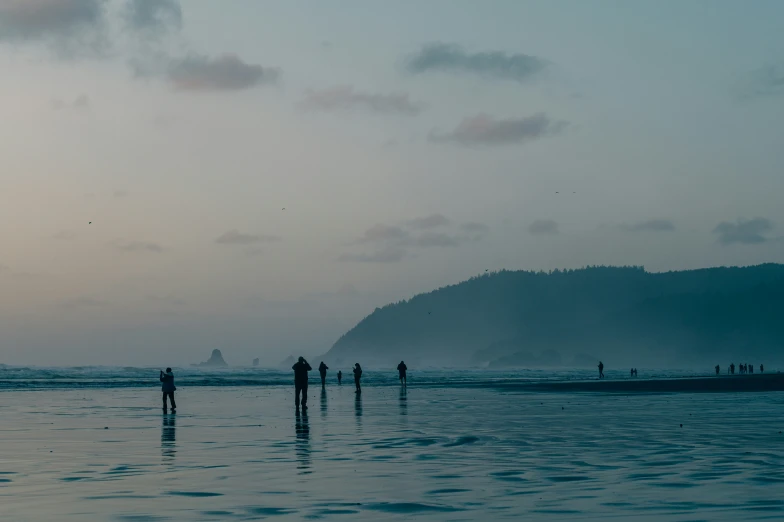 people are standing in the ocean watching the waves