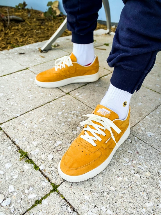 the feet of a person wearing yellow shoes