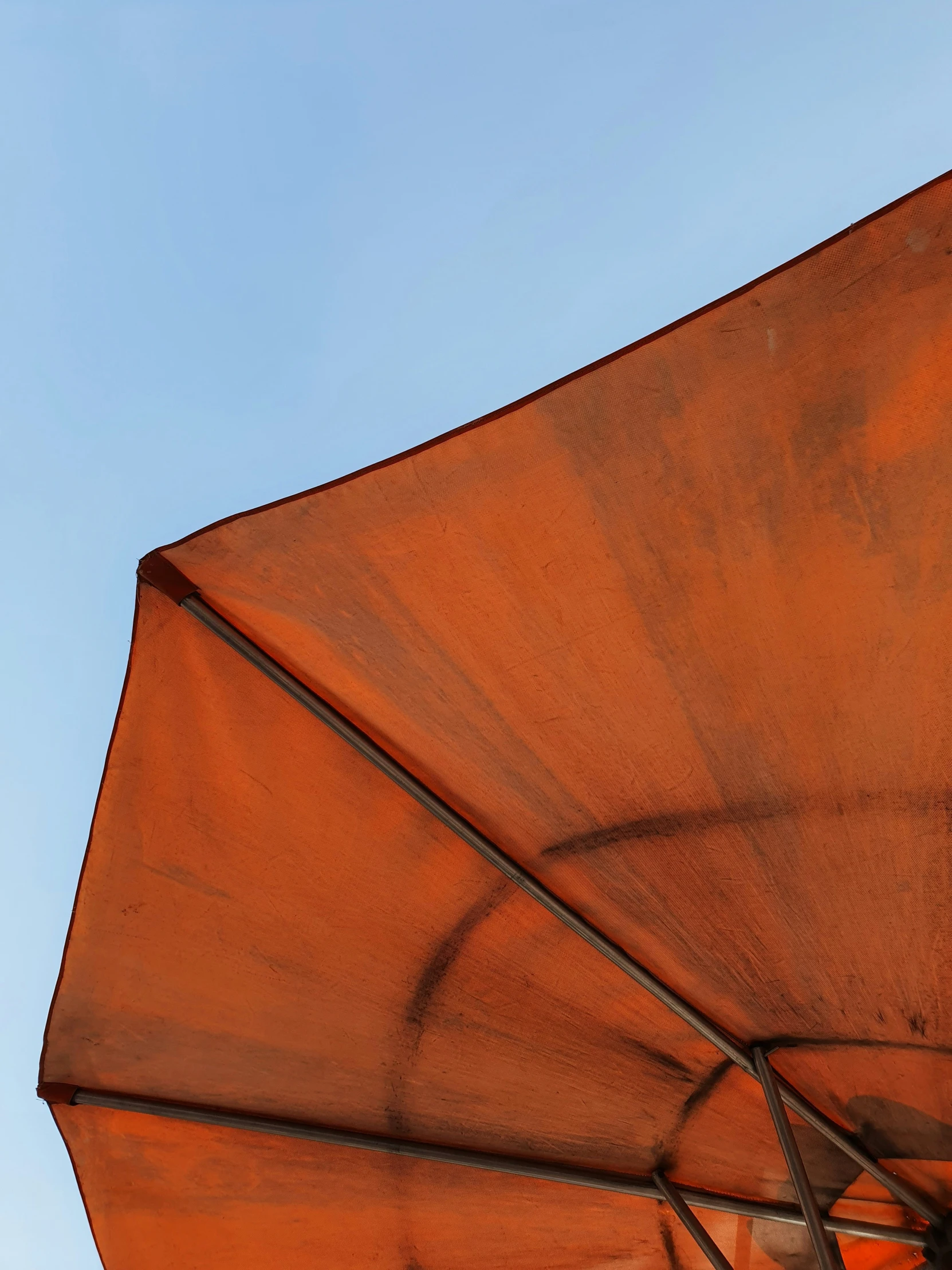 an orange umbrella that is opened up in the sky