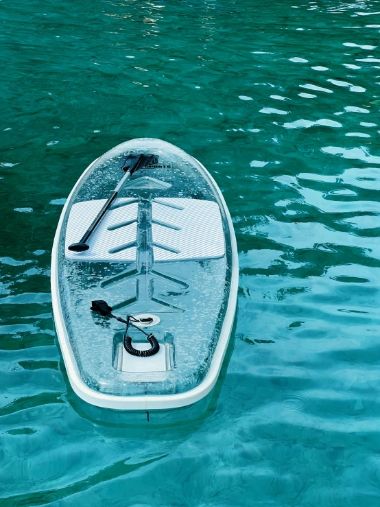 a blue canoe floating on the water with an oar