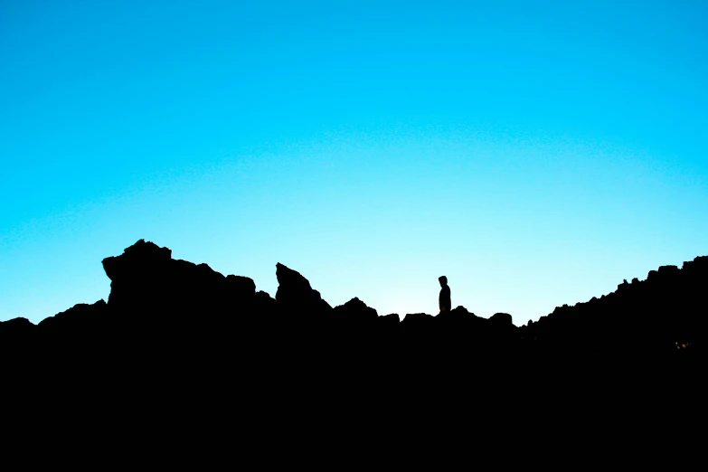 a black and blue sky above some rocks