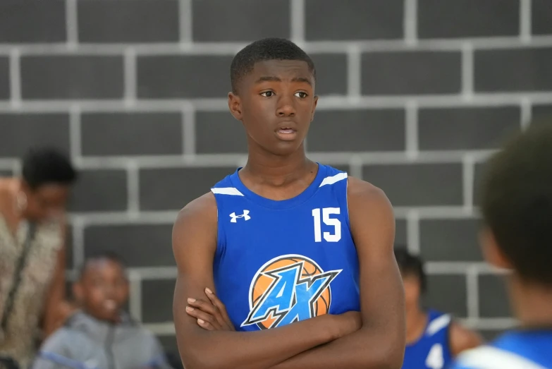 a boy is wearing a blue uniform while standing on a court