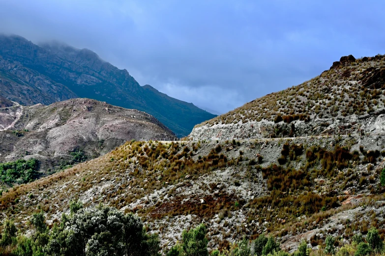 a mountain range is shown near a bushy hill