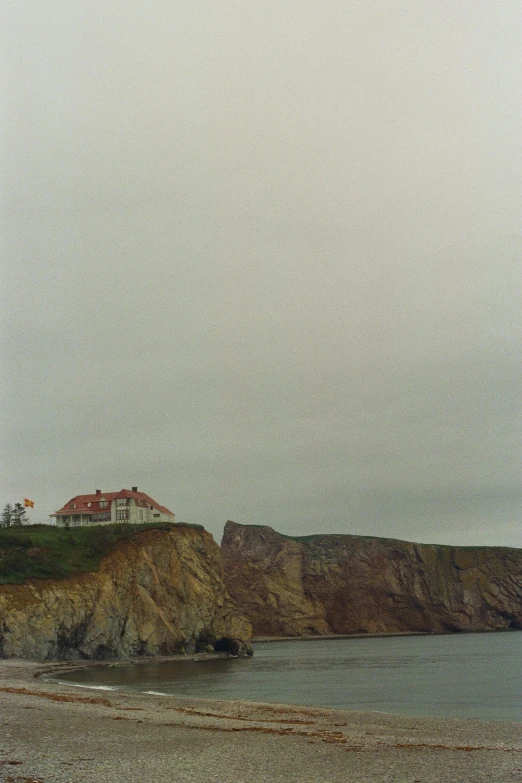 a lighthouse and a boat sit on a rocky shore