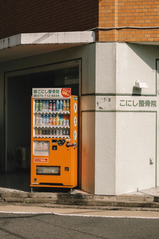 the vending machine is outside the building by the curb