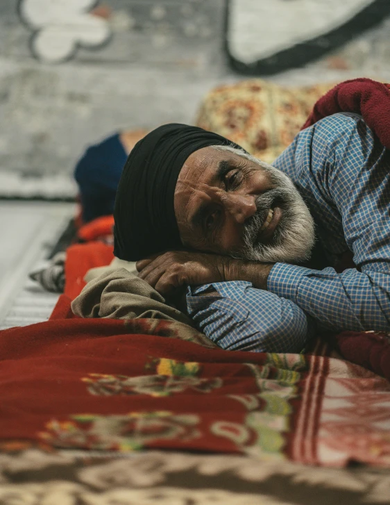 man with head covering lying on bed in home