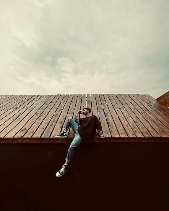 a person sitting on top of a roof next to a building